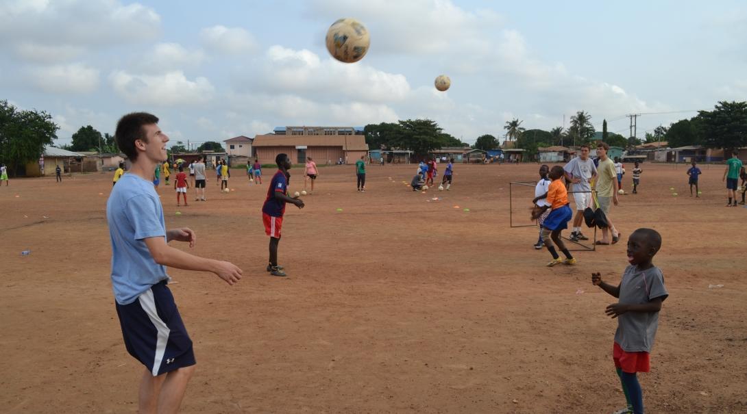 A child practices football skills with a gap year student in Ghana, West Africa. A gap year volunteer practices football drills with a young player at a Football Project in Ghana, Africa.